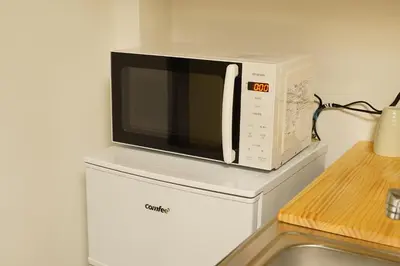 a microwave sitting on top of a refrigerator at Remon House Asakusa Tokyo in Tokyo