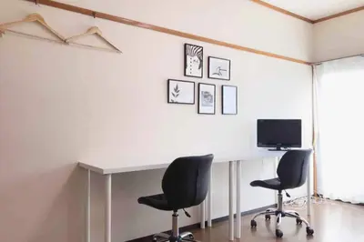 a room with a desk with two chairs and a television at Yamato Heights YH22 in Tokyo