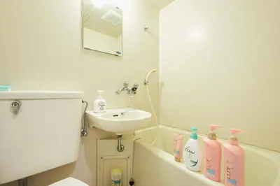 a bathroom with a sink and a bath tub with bottles at Yamato Heights YH22 in Tokyo