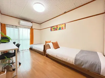 a hotel room with two beds and a desk at Yamato Heights YH22 in Tokyo