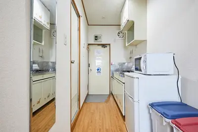a kitchen with a refrigerator and a microwave at Yamato Heights YH27 in Tokyo