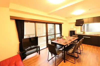 a dining room with a table with chairs and a television at Nishigokencho NA2 in Tokyo
