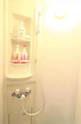 a white refrigerator with a hose in a bathroom at Nishigokencho NA2 in Tokyo