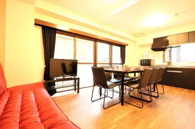 a living room with a couch and a table with chairs at Nishigokencho NA2 in Tokyo