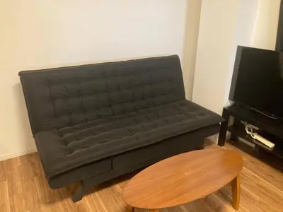 a black couch in a living room with a table at Nishigokencho NA2 in Tokyo