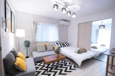 a living room with a couch and a table at COMMA HOUSE Nishi-Ikebukuro 11 in Tokyo