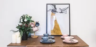 a table with plates and cups and a vase with flowers at COMMA HOUSE Nishi-Ikebukuro 11 in Tokyo