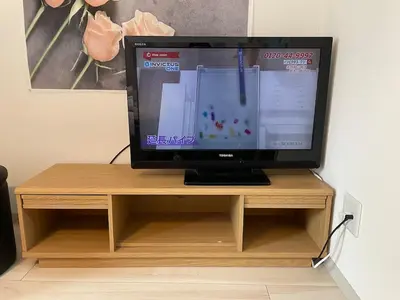 a computer monitor sitting on top of a wooden stand at COMMA HOUSE Nishi-Ikebukuro 11 in Tokyo