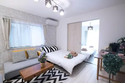 a living room with a couch and a table at COMMA HOUSE Nishi-Ikebukuro 11 in Tokyo