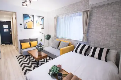 a bedroom with a bed and a living room at COMMA HOUSE Nishi-Ikebukuro 11 in Tokyo