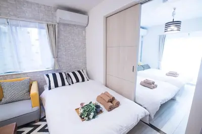 a small bedroom with two beds and a couch at COMMA HOUSE Nishi-Ikebukuro 11 in Tokyo