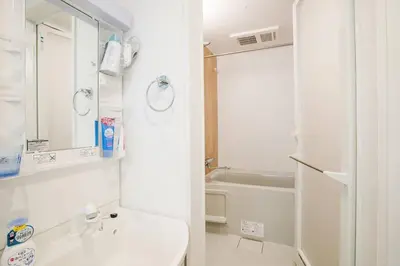 a white bathroom with a sink and a shower at COMMA HOUSE Nishi-Ikebukuro 2 UNITS 2131 in Tokyo
