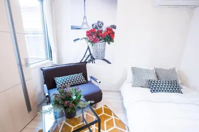 a living room with a couch and a chair at COMMA HOUSE Nishi-Ikebukuro 2 UNITS 2131 in Tokyo