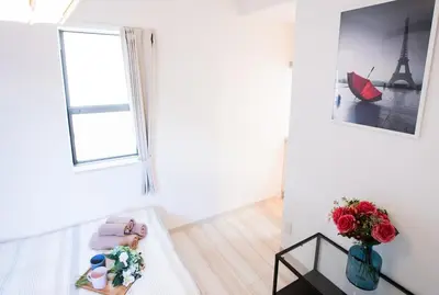 a white room with a vase of flowers and a window at COMMA HOUSE Nishi-Ikebukuro 2 UNITS 2131 in Tokyo