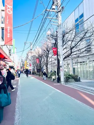 a city street with people walking on the sidewalk at Shinjuku Suginami in Tokyo