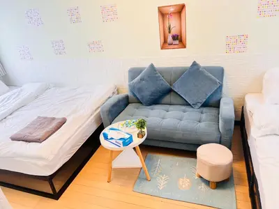 a living room with a couch and a bed at Shinjuku Suginami in Tokyo