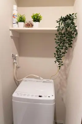 a shelf above a washing machine with plants on it at FL Residence Kagura Futei II in Tokyo