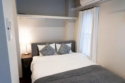 a bed in a small room with a window at FL Residence Kagura Futei II in Tokyo