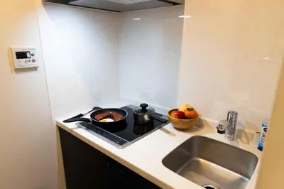 a kitchen with a sink and a stove with pots and pans at FL Residence Kagura Futei II in Tokyo