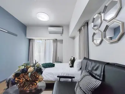 a living room with a bed and a couch at GM35\u65b0\u5bbf\u4e2d\u5fc3 \u8d85\u7ea7\u5546\u5708 \u4ea4\u901a\u67a2\u7ebd \u8f66\u7ad98\u5206\u949f \u6700\u59273\u4eba Shinjuku center 8 mins to ST 3P Maxs \u76f4\u8fbe\u65b0\u5bbf \u6d89\u8c37 \u8868\u53c2\u9053 \u54c1\u5ddd \u6c60\u888b \u4e0a\u91ce \u4ee3\u4ee3\u6728 \u94f6\u5ea7 \u539f\u5bbf in Tokyo