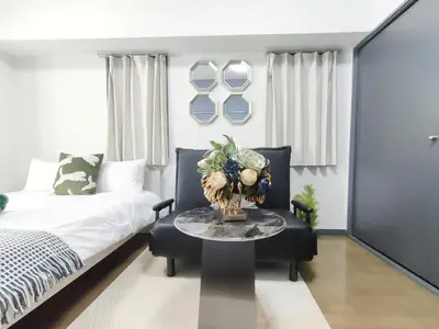 a bedroom with a bed and a table with a vase on it at GM35\u65b0\u5bbf\u4e2d\u5fc3 \u8d85\u7ea7\u5546\u5708 \u4ea4\u901a\u67a2\u7ebd \u8f66\u7ad98\u5206\u949f \u6700\u59273\u4eba Shinjuku center 8 mins to ST 3P Maxs \u76f4\u8fbe\u65b0\u5bbf \u6d89\u8c37 \u8868\u53c2\u9053 \u54c1\u5ddd \u6c60\u888b \u4e0a\u91ce \u4ee3\u4ee3\u6728 \u94f6\u5ea7 \u539f\u5bbf in Tokyo