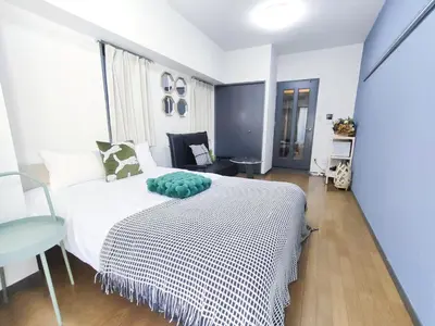 a bedroom with a white bed and a table at GM35\u65b0\u5bbf\u4e2d\u5fc3 \u8d85\u7ea7\u5546\u5708 \u4ea4\u901a\u67a2\u7ebd \u8f66\u7ad98\u5206\u949f \u6700\u59273\u4eba Shinjuku center 8 mins to ST 3P Maxs \u76f4\u8fbe\u65b0\u5bbf \u6d89\u8c37 \u8868\u53c2\u9053 \u54c1\u5ddd \u6c60\u888b \u4e0a\u91ce \u4ee3\u4ee3\u6728 \u94f6\u5ea7 \u539f\u5bbf in Tokyo