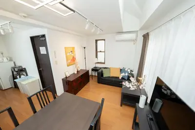 a living room with a table and a couch at XS14 XROSS STAY Higashi shinjuku1 \u6771\u65b0\u5bbf in Tokyo