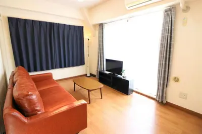 a living room with a leather couch and a table at Cosmy-2 IC53 in Tokyo