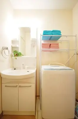 a bathroom with a sink and a toilet and a mirror at Cosmy-2 IC53 in Tokyo
