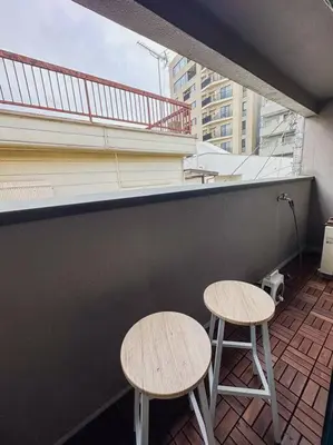 two tables and stools on a balcony of a building at Shibuya area large Home 10m walking to Shibuya Stream Building in Tokyo