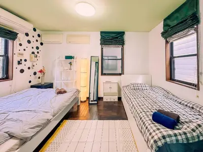 a bedroom with two beds and two windows at Shibuya area large Home 10m walking to Shibuya Stream Building in Tokyo