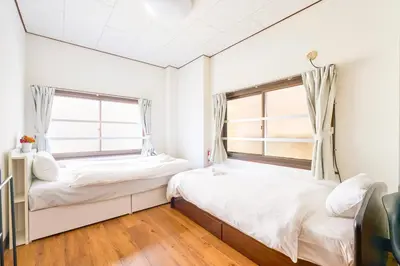 two beds in a room with two windows at Kinshicho detached house KK23 in Tokyo