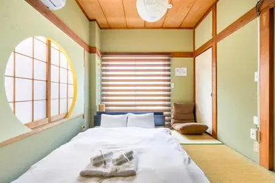 a bedroom with a bed with two shoes on it at Kinshicho detached house KK23 in Tokyo
