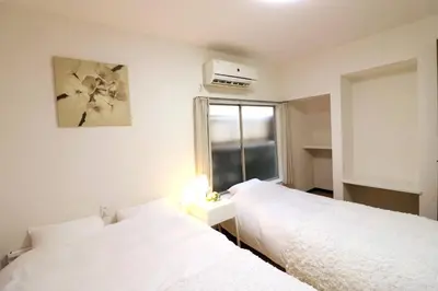two white beds in a room with a window at Nishi Shinjuku House Five 1F HF1 in Tokyo