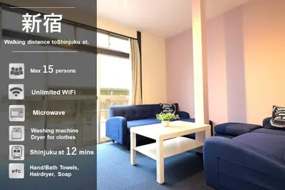 a living room with two blue couches and a table at Nishi Shinjuku House Five 1F HF1 in Tokyo