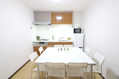a kitchen and dining room with a white table and chairs at Nishi Shinjuku House Five 1F HF1 in Tokyo
