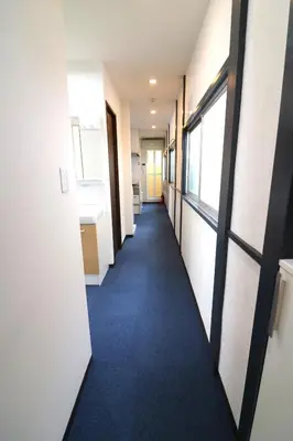 a hallway of an office building with a blue carpet at Nishi Shinjuku House Five 2F HF2 in Tokyo