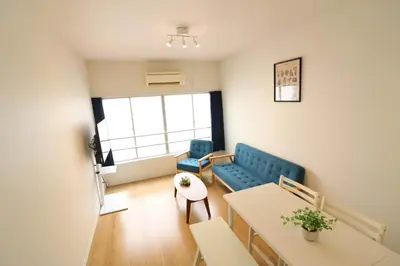 a living room with a blue couch and a table at Nishi Shinjuku House Five 2F HF2 in Tokyo