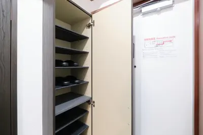 a walk in closet with black shoes at Marine Cove Hatsudai by Tranova in Tokyo