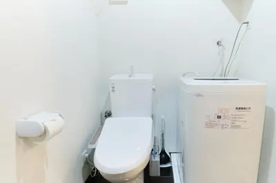 a bathroom with a white toilet and a sink at Marine Cove Hatsudai by Tranova in Tokyo