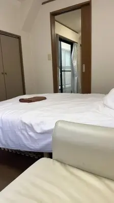 a bedroom with two beds and a mirror at \u6574\u5957\u79c1\u4eba\u7a7a\u95f4 \u6674\u7a7a\u5854 \u89c2\u666f\u9633\u53f0 in Tokyo