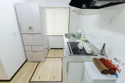 a white kitchen with a stove and a refrigerator at QiQi House Tokyo Hirai Villa 2Bath3WCs 4min Station 24min to Akihabara in Tokyo