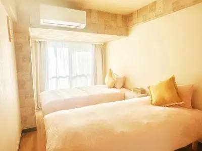 a hotel room with two beds and a window at \u65b0\u5bbf\u6b4c\u821e\u4f0e\u753a\u8212\u9002\u516c\u5bd3#7 in Tokyo