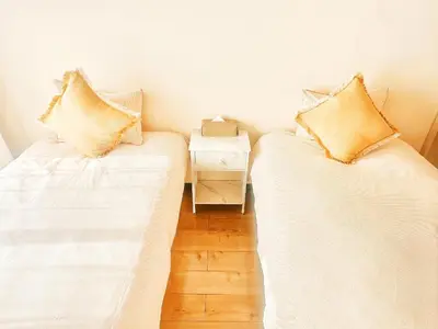 two white beds in a room with a side table at \u65b0\u5bbf\u6b4c\u821e\u4f0e\u753a\u8212\u9002\u516c\u5bd3#7 in Tokyo