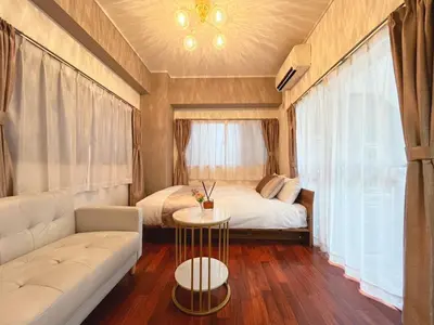 a bedroom with a bed and a couch and a table at Tobu High Line Daimon 201 TH1 in Tokyo