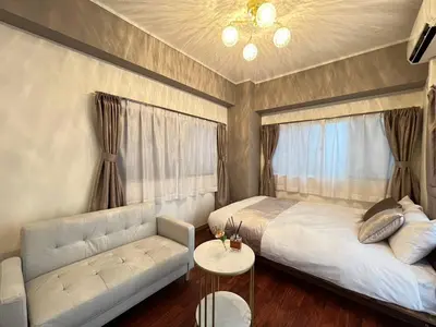 a bedroom with a bed and a couch and a table at Tobu High Line Daimon 201 TH1 in Tokyo