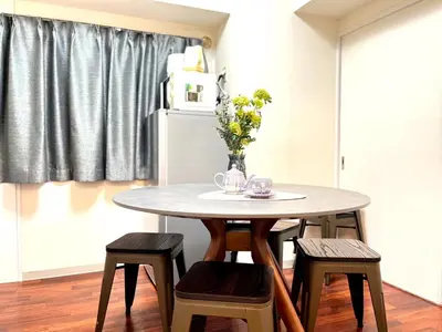 a dining room table with chairs and a vase of flowers at Tobu High Line Daimon 201 TH1 in Tokyo