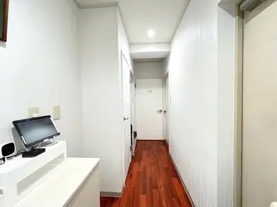 a hallway with white walls and a television on a counter at Tobu High Line Daimon 201 TH1 in Tokyo