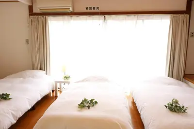 two beds in a room with a large window at Senkawa CV House SC1 in Tokyo
