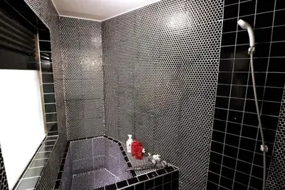 a bathroom with a black tiled shower with a red fire hydrant at Senkawa CV House SC1 in Tokyo